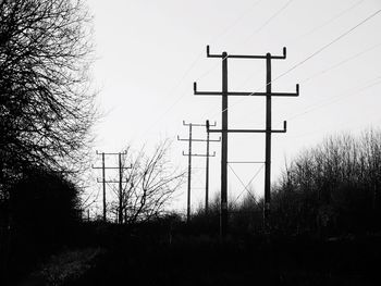 Silhouette of electricity pylon against sky