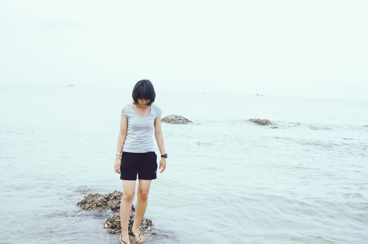 water, sea, standing, full length, rear view, beach, lifestyles, horizon over water, casual clothing, leisure activity, clear sky, copy space, shore, tranquility, nature, beauty in nature, tranquil scene, walking