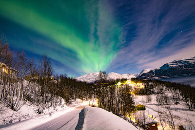 Scenic view of snow covered mountains against sky at night