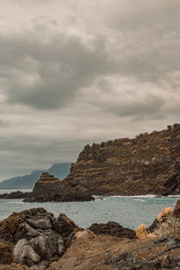 Rock formations by sea against sky