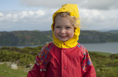 Portrait of smiling boy standing against yellow sky