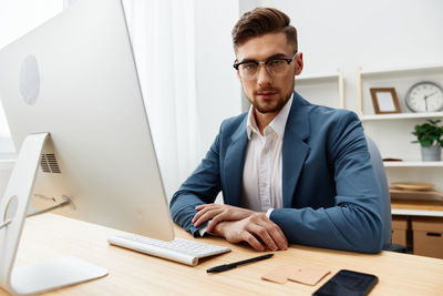 Portrait of businessman working at desk in office