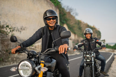 Portrait of man riding motorcycle on road