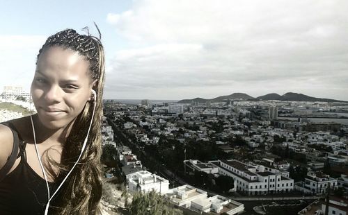 Portrait of beautiful woman against buildings in city