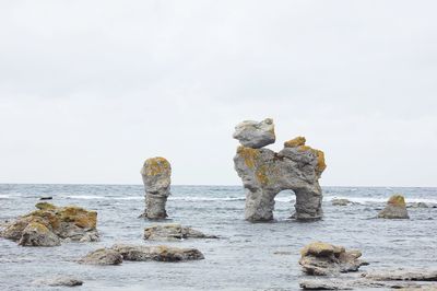 Rocks on beach against sky