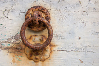 Close-up of old rusty metal hanging against wall