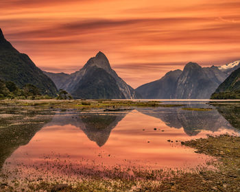 Scenic view of lake against orange sky