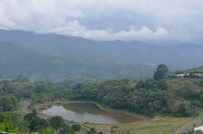 High angle view of river and mountains against sky