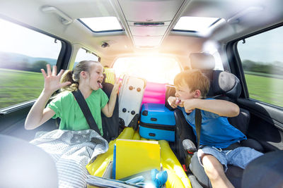 Siblings playing in car