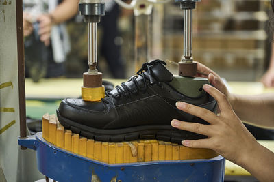 Detail of woman's hands while checking the shoes in quality control production line in chinese shoes factory