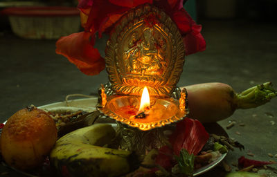 Ganesha idol and burning diya in plate