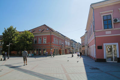 People walking on street amidst buildings in city