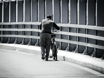 Rear view of man riding bicycle on street