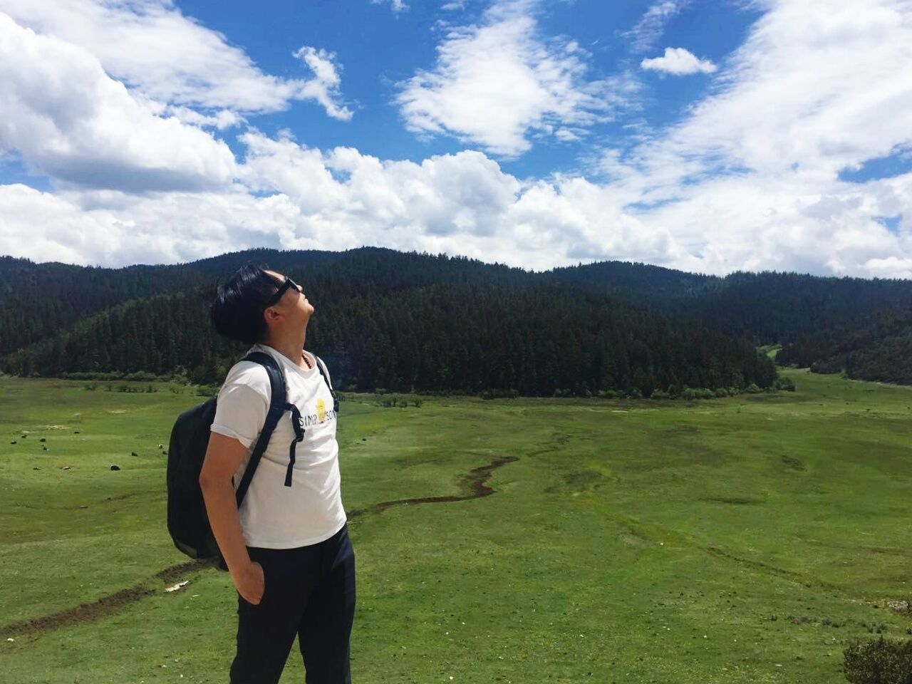 mountain, sky, lifestyles, landscape, mountain range, leisure activity, tranquil scene, casual clothing, standing, tranquility, scenics, cloud - sky, beauty in nature, nature, young adult, cloud, grass, field