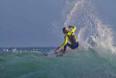 Man surfing in sea against sky