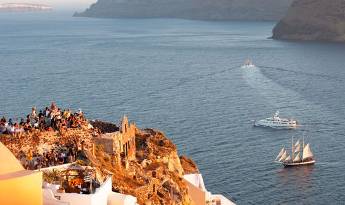 Tourist people at the roof of a house waiting for the  sunset in santorini, greek island, greece