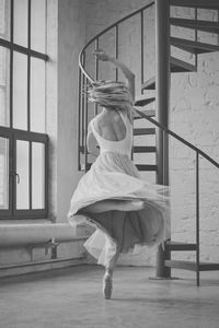 Rear view of woman dancing by staircase