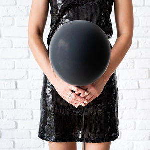 Midsection of woman holding umbrella standing against wall