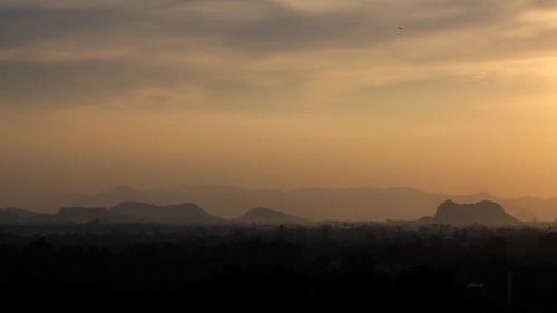 Scenic view of silhouette mountains against sky during sunset