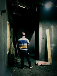 Rear view of man standing in abandoned building