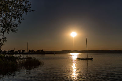 Boats in sea at sunset