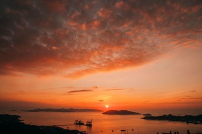 Scenic view of sea against dramatic sky during sunset