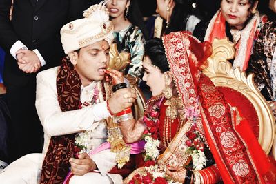 Couple feeding nuts during wedding ceremony