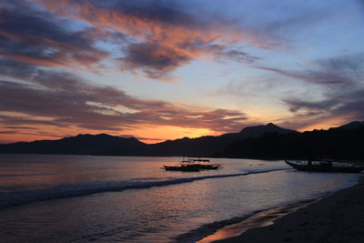 Scenic view of sea against dramatic sky during sunset