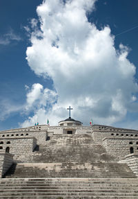 Low angle view of building against cloudy sky