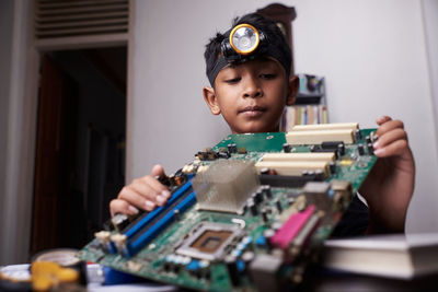 Portrait of boy holding toy at home