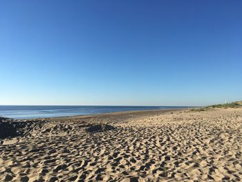 Scenic view of beach against clear blue sky