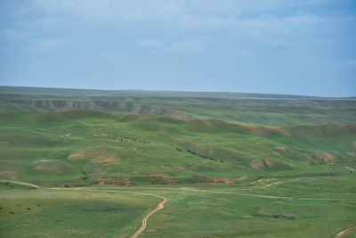 A picturesque view from the rocks to the hills with green fields under the eternal blue sky