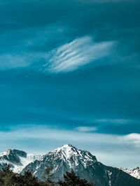 Scenic view of snowcapped mountains against blue sky