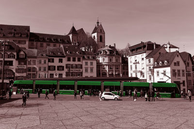 Group of people on street against buildings in city