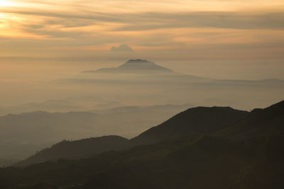 Scenic view of silhouette mountains against sky during sunset