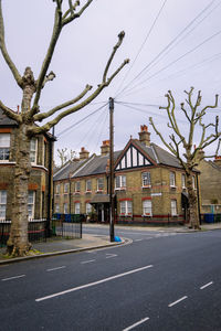 Road by buildings against sky