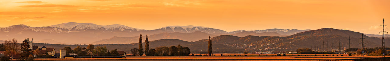 Styrian alps covered with snow in orange light of sunset. view at mountain chain of lavanttaler alps 