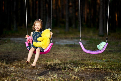 Cute girl sitting on swing at park
