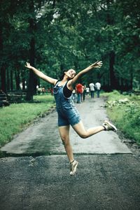 Full length of happy woman jumping in park