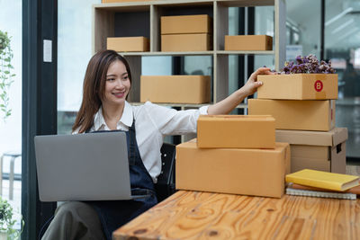 Portrait of woman using digital tablet while sitting on table