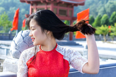 Smiling young woman holding hair