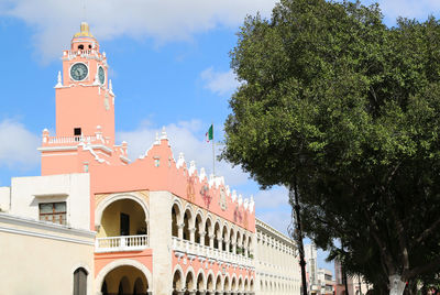 Low angle view of trees and buildings against sky