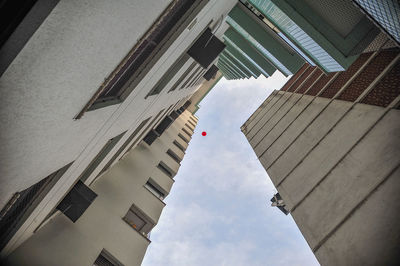 Low angle view of balloon amidst skyscrapers against sky