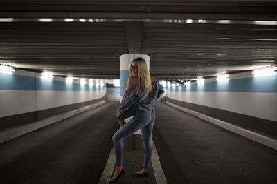 Woman standing in illuminated subway station