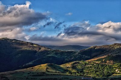 Scenic view of mountains against cloudy sky