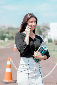 Smiling young woman using mobile phone