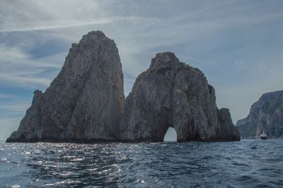 Rock formation in sea against sky