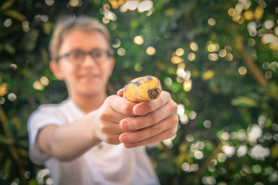 Portrait of smiling boy holding leaf