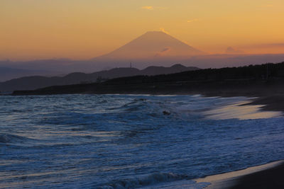 Scenic view of sea against orange sky