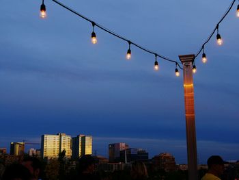 Illuminated city against sky at dusk